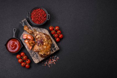 Koyu beton arka planda elma ve sos ile pişirilmiş ördek bacağı.