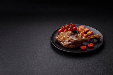 Koyu beton arka planda elma ve sos ile pişirilmiş ördek bacağı.