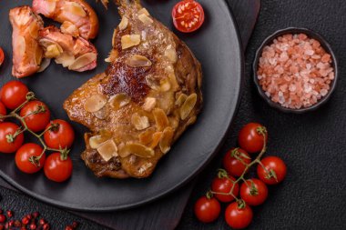 Koyu beton arka planda elma ve sos ile pişirilmiş ördek bacağı.