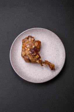 Koyu beton arka planda elma ve sos ile pişirilmiş ördek bacağı.