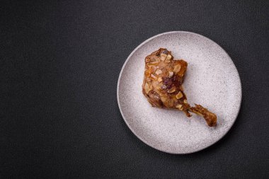 Koyu beton arka planda elma ve sos ile pişirilmiş ördek bacağı.