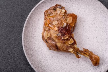 Koyu beton arka planda elma ve sos ile pişirilmiş ördek bacağı.