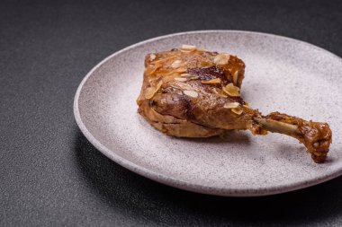 Koyu beton arka planda elma ve sos ile pişirilmiş ördek bacağı.