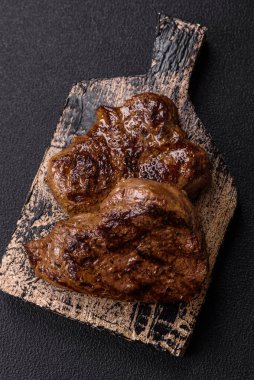 Tuz, baharat ve otlarla kaplanmış, koyu dokulu ızgara biftek.