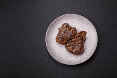 Tuz, baharat ve otlarla kaplanmış, koyu dokulu ızgara biftek.