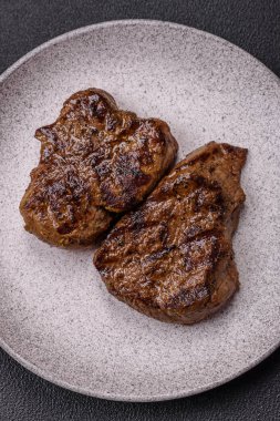 Tuz, baharat ve otlarla kaplanmış, koyu dokulu ızgara biftek.