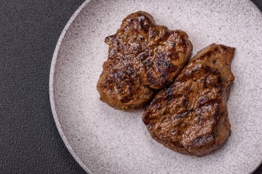 Tuz, baharat ve otlarla kaplanmış, koyu dokulu ızgara biftek.