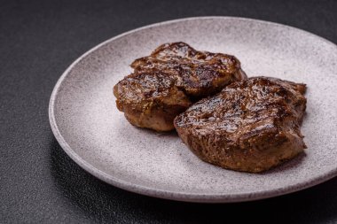 Tuz, baharat ve otlarla kaplanmış, koyu dokulu ızgara biftek.