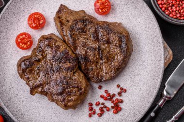 Tuz, baharat ve otlarla kaplanmış, koyu dokulu ızgara biftek.