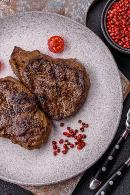 Tuz, baharat ve otlarla kaplanmış, koyu dokulu ızgara biftek.