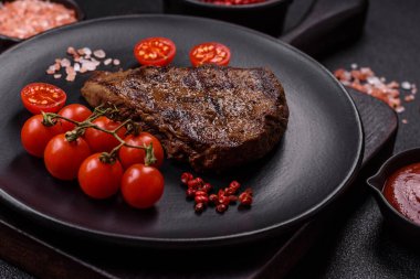 Tuz, baharat ve otlarla kaplanmış, koyu dokulu ızgara biftek.