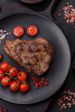Tuz, baharat ve otlarla kaplanmış, koyu dokulu ızgara biftek.