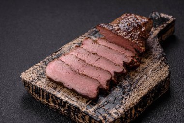 Tuz, baharat ve otlarla kaplanmış, koyu dokulu ızgara biftek.