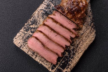 Tuz, baharat ve otlarla kaplanmış, koyu dokulu ızgara biftek.