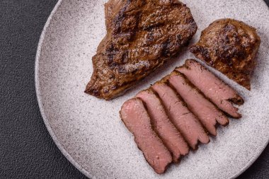 Tuz, baharat ve otlarla kaplanmış, koyu dokulu ızgara biftek.