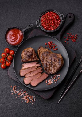 Tuz, baharat ve otlarla kaplanmış, koyu dokulu ızgara biftek.