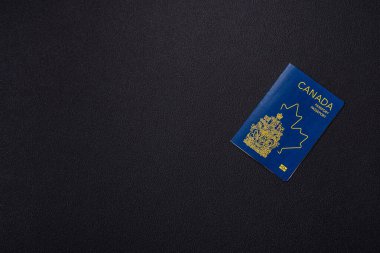 Koyu beton arka planda, uluslararası seyahat yapan bir Kanada vatandaşının uluslararası pasaportu