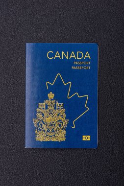 Koyu beton arka planda, uluslararası seyahat yapan bir Kanada vatandaşının uluslararası pasaportu