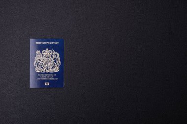 Büyük Britanya ve Kuzey İrlanda vatandaşının uluslararası pasaportu koyu beton arka planda, uluslararası seyahat