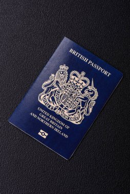 Büyük Britanya ve Kuzey İrlanda vatandaşının uluslararası pasaportu koyu beton arka planda, uluslararası seyahat