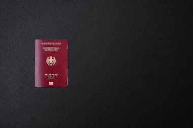 Almanya vatandaşının uluslararası pasaportu koyu beton arka planda, uluslararası seyahat