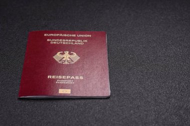 Almanya vatandaşının uluslararası pasaportu koyu beton arka planda, uluslararası seyahat