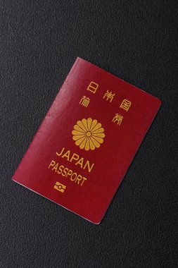 Koyu beton arka planda bir Japon vatandaşının uluslararası pasaportu, uluslararası seyahat