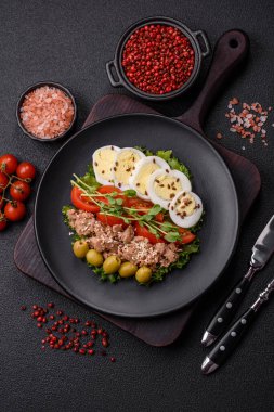 Ton balıklı salata, haşlanmış yumurta, vişneli domates, marul, tuz, baharat ve mikroyeşillik.