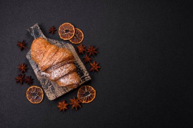 Lezzetli çıtır kruvasan, koyu beton arka planda çikolatalı.