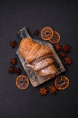 Lezzetli çıtır kruvasan, koyu beton arka planda çikolatalı.