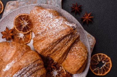 Lezzetli çıtır kruvasan, koyu beton arka planda çikolatalı.