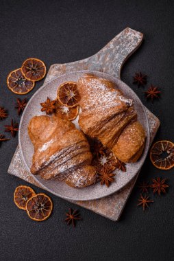 Lezzetli çıtır kruvasan, koyu beton arka planda çikolatalı.