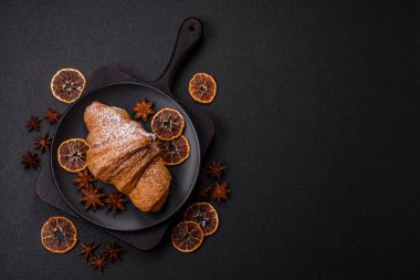 Lezzetli çıtır kruvasan, koyu beton arka planda çikolatalı.