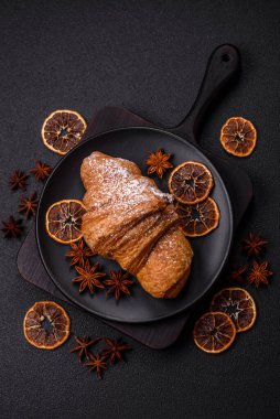 Lezzetli çıtır kruvasan, koyu beton arka planda çikolatalı.