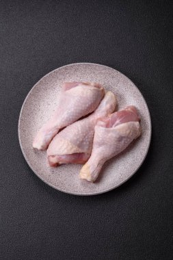 Tuzlu, baharatlı ve çimento kaplı çiğ tavuk bacakları. Evde yemek pişirmek.