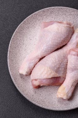 Tuzlu, baharatlı ve çimento kaplı çiğ tavuk bacakları. Evde yemek pişirmek.