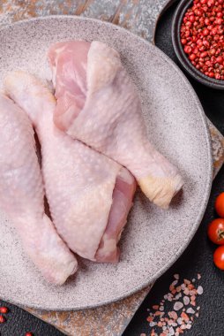 Tuzlu, baharatlı ve çimento kaplı çiğ tavuk bacakları. Evde yemek pişirmek.