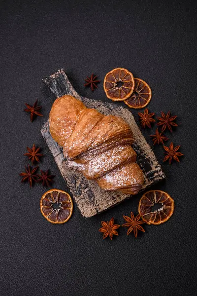 Lezzetli çıtır kruvasan, koyu beton arka planda çikolatalı.