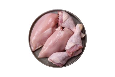 Çiğ tavuk parçaları ya da hindi filetosu. Beyaz arka planda tuz, baharat ve otlarla birlikte.