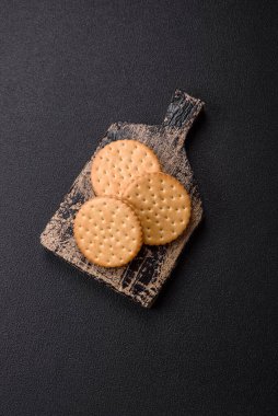 Koyu beton arka planda kremalı yuvarlak atıştırmalık kurabiyeler. Kahvaltıda tatlı.