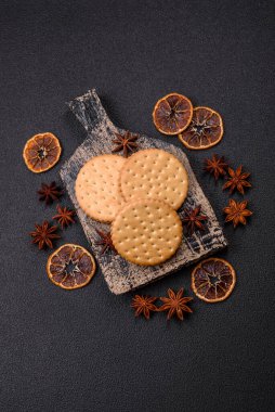 Koyu beton arka planda kremalı yuvarlak atıştırmalık kurabiyeler. Kahvaltıda tatlı.