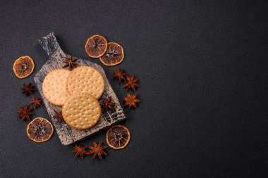 Koyu beton arka planda kremalı yuvarlak atıştırmalık kurabiyeler. Kahvaltıda tatlı.