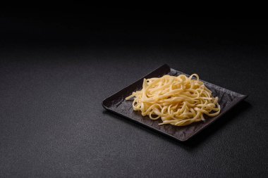 Fasulyeli erişte, et, domates sosu, baharatlar ve otlar koyu beton arka planda.