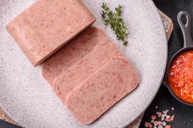 Lezzetli konserve pembe baharatlı jambon ya da arka planda tuz, baharat ve otlu konserve jambon.