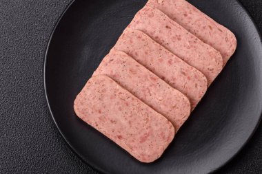 Lezzetli konserve pembe baharatlı jambon ya da arka planda tuz, baharat ve otlu konserve jambon.