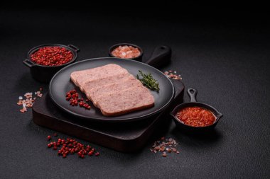 Lezzetli konserve pembe baharatlı jambon ya da arka planda tuz, baharat ve otlu konserve jambon.