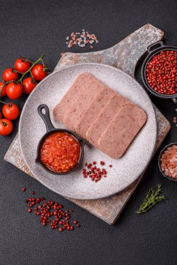 Lezzetli konserve pembe baharatlı jambon ya da arka planda tuz, baharat ve otlu konserve jambon.