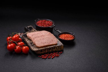 Lezzetli konserve pembe baharatlı jambon ya da arka planda tuz, baharat ve otlu konserve jambon.