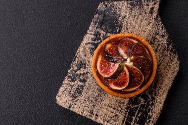 İncirli tatlı tart, peynirli krema ve fındıklı koyu beton arka plan
