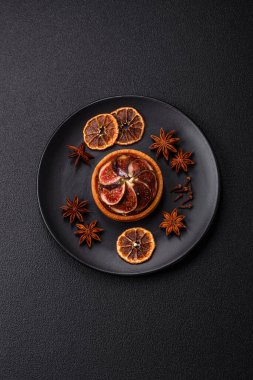 İncirli tatlı tart, peynirli krema ve fındıklı koyu beton arka plan